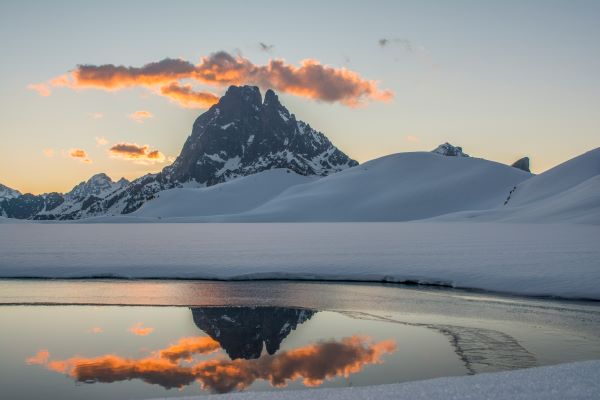Pic du midi d'Ossau l'hiver enneigé avec un nuage doré béret béarnais. Tableau photo. Pyrénées, montagne.
